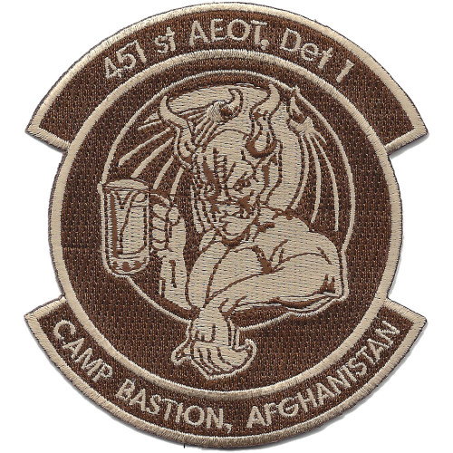 Circular desert tan embroidered patch with subdued maroon scrolls reading "451st AEOT, Det 1" at top and "Camp Bastion, Afghanistan" at bottom, and a seated gargoyle with bat wings at center, all in monochrome tan and brown.