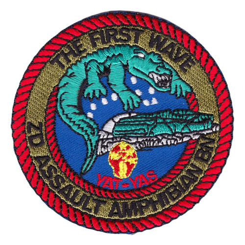 Round 2nd Assault Amphibian Battalion patch with a red rope border, THE FIRST WAVE across the top, and a green alligator climbing over an amphibious tractor on a blue field.