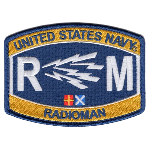 Embroidered United States Navy Radioman RM rating patch with gold and navy blue field, white lightning bolt cluster, large R and M letters, naval signal flags, and merrowed border. Measures 4.5 by 3.25 inches.