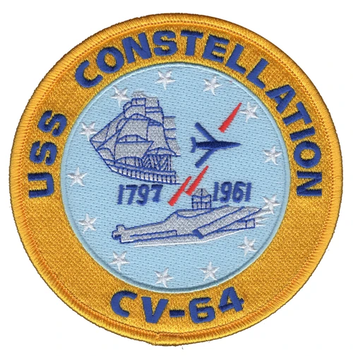 Round USS Constellation CV-64 patch with a gold border, the 1797 frigate and the 1961 carrier on light blue with a jet, two red missiles and a ring of white stars.