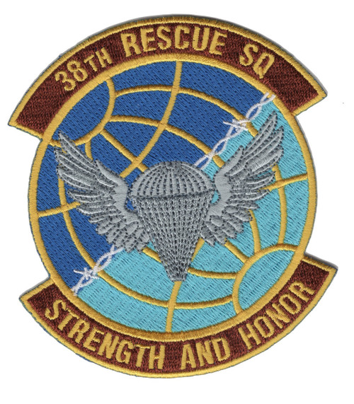 Circular embroidered patch with blue-to-teal gridded globe field, gold border, silver winged parachutist descending at center, maroon scrolls reading "38th Rescue SQ" at top and "Strength and Honor" at bottom.