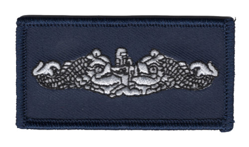 Small navy blue rectangle patch with silver-white embroidered submarine dolphins flanking the bow and conning tower of a submarine, finished with a navy merrowed edge.