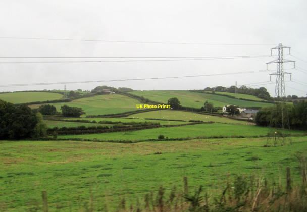 Photo 6"x4" View from a Plymouth-Exeter train - fields and pylons near Bow Grange Ipplepen c2016