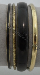 Thin black bangle with a subtle sheen

Very thin gold-tone spacer (smooth, narrow band)

Antiqued gold bangle with an engraved/embossed floral or vine pattern

Wide glossy black bangle (the thickest one, smooth finish)

Thicker gold-tone bangle with a slightly aged/brushed look

Overall vibe: classic black-and-gold stacked bangle set, with a mix of minimal smooth pieces and one ornate textured centerpiece for contrast.