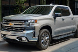 Silver Chevrolet Silverado parked outside of building. Silver Chevrolet Silverado parked outside of building.