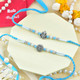 Ganesh And Suriya Set Of Two Rakhi With Besan Laddu