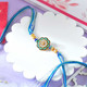 Floral Shaped Rakhi With Blue Thread