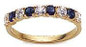 Prong set round lab grown diamond look cubic zirconia and man made sapphire anniversary band in 14k yellow gold.