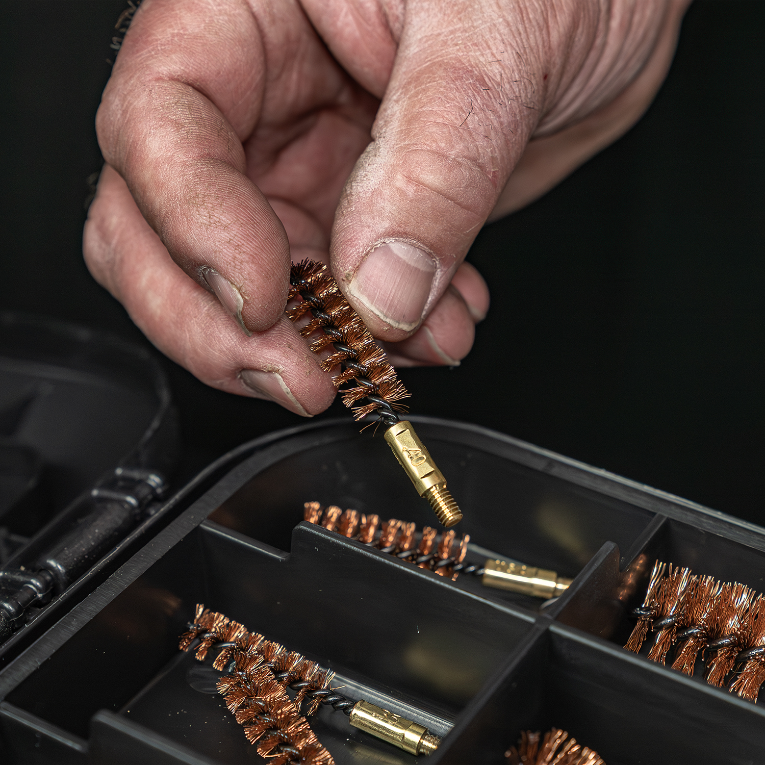 LIfestyle image of Otis Elite Range Box, Universal Gun Care System bore brush being removed from box