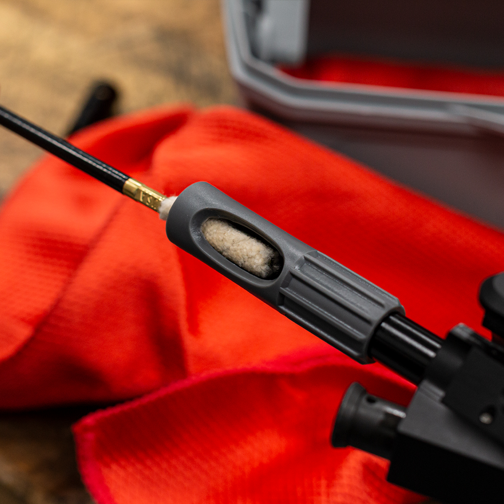 Lifestyle image of  image of universal bore guide in use with gun cleaning rod and mop