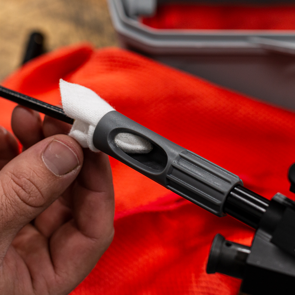 Lifestyle image of  image of universal bore guide in use with gun cleaning rod and patch
