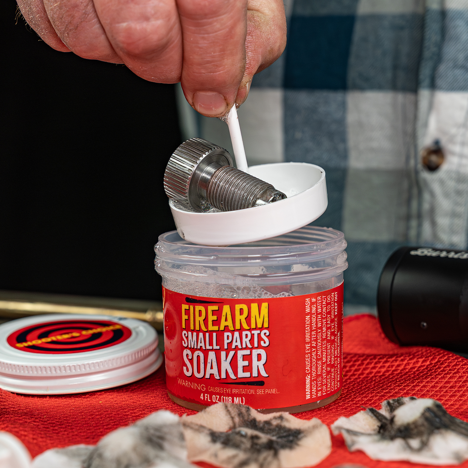 Product image of Shooter's Choice Firearm Small Parts Soaker 4oz shown in use with muzzleloader breech plug