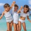 Girls wearing Shade Critters Cottage Floral Blue smocked one piece swimsuits at the beach.