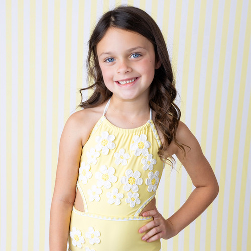 Girls Butter Yellow Daisy one piece swimsuit on model showing fit.