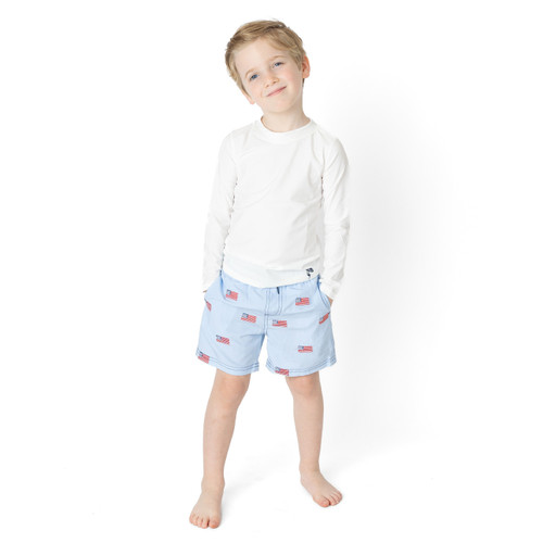 Boys flag print swim trunks with water activated design, cute kids swimwear shown on model.