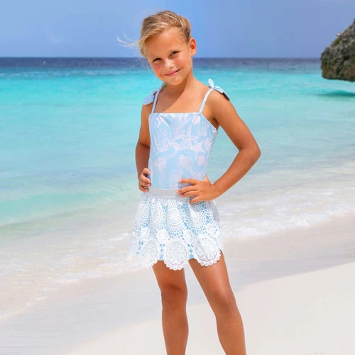 Shade Critters girls one piece swimsuit with crochet skirt cover up in snorkel splash blue, stylish kids swimwear shown on beach.