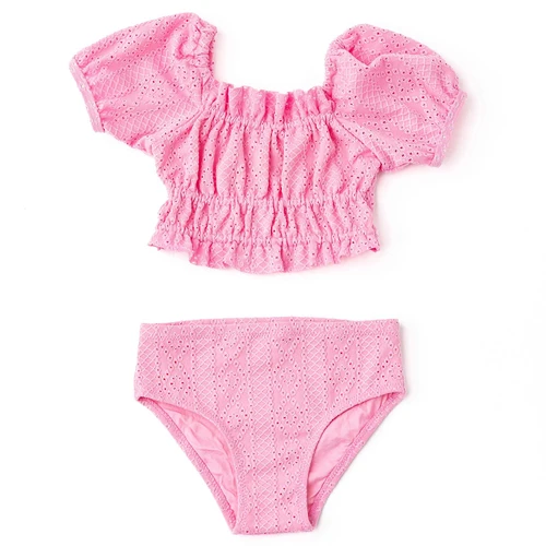 Girls pink smocked bikini set with puff sleeves and eyelet texture, trendy kids two piece swimsuit.