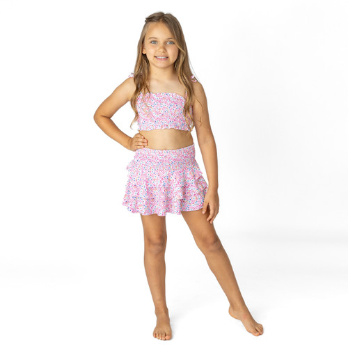 Girls floral smocked skirt cover up in bright ditsy print, lightweight kids swimwear styled on model.