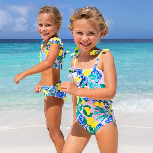 Girls citrus print ruffle one piece swimsuit, colorful kids swimwear shown on models at the beach, perfect for summer vacation.