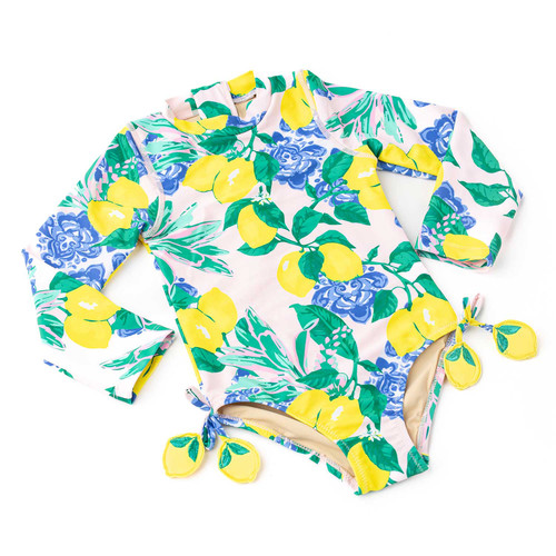 Girls long sleeve one piece swimsuit in vibrant citrus and floral print with side tie tassel details, stylish kids swimwear.