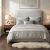 Assisi upholstered bedhead with French seam edging, front view in a neutral bedroom