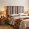 Florence panelled bedhead in neutral upholstery, angled view beside a timber bedside table