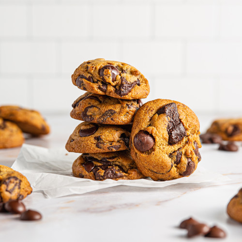A close-up of a stack of five chocolate chip cookies. The cookies are golden brown and have melty chocolate chips throughout.
A stack of delicious chocolate chip cookies, ready to be enjoyed.
A tempting close-up of homemade chocolate chip cookies.