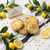 The Main Squeeze gourmet lemon cookie with white chocolate chips and lemon curd center on white marble by In The Black Cookie Co.