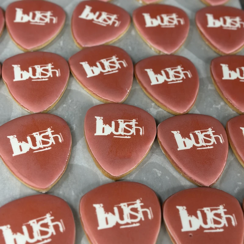 Guitar-pick cookies printed with the Bush logo.