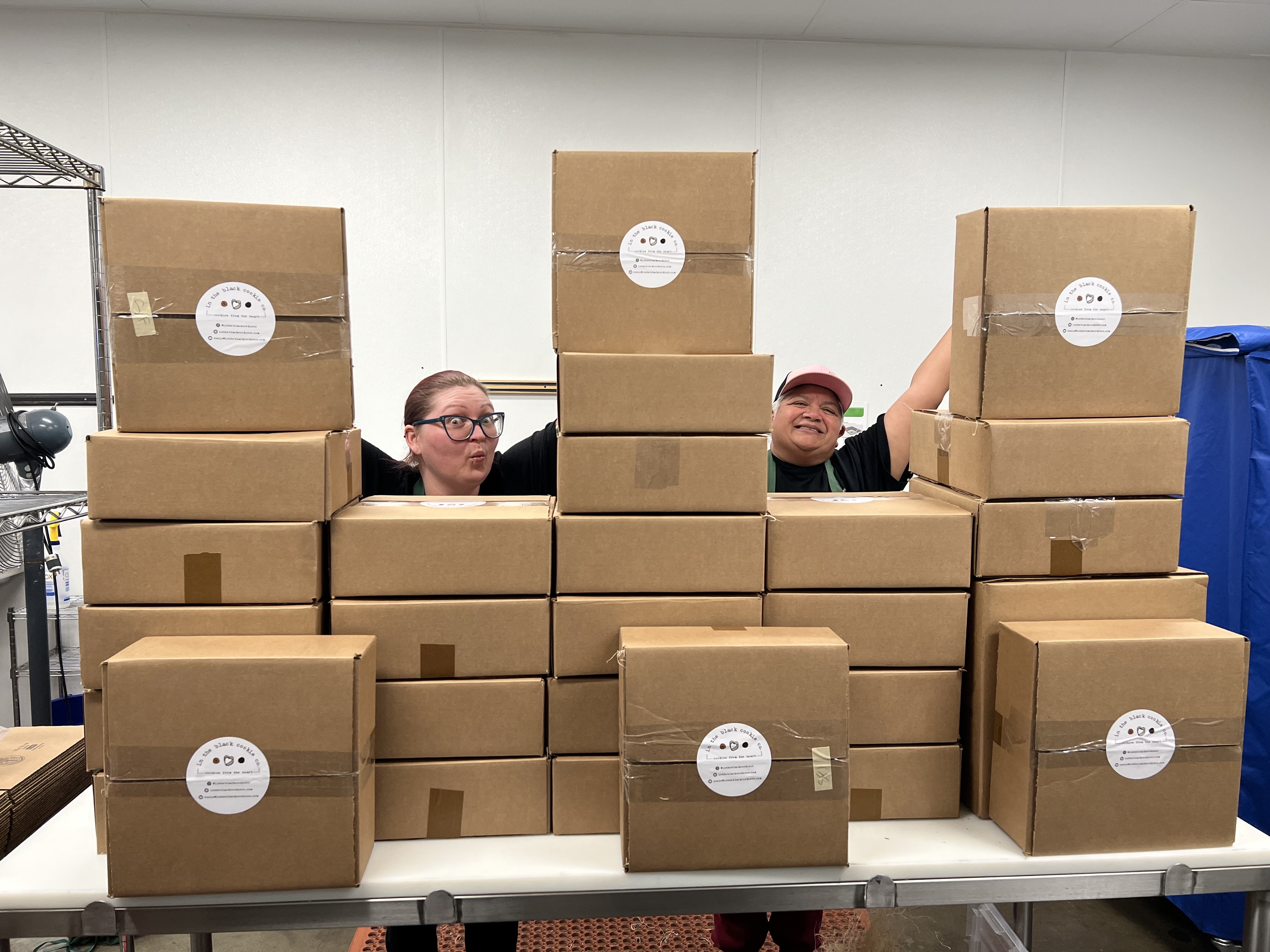 two chefs standing behind boxes ready to ship