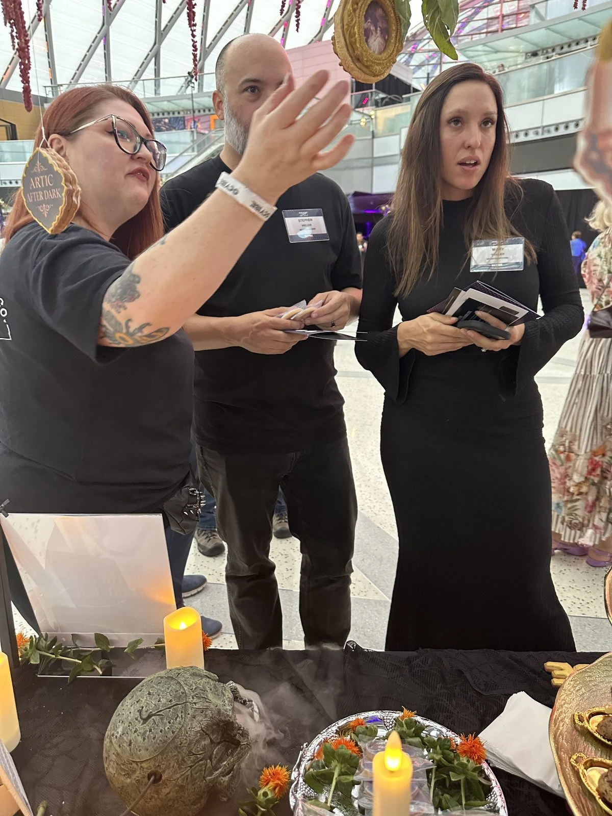 Arctic After Dark guests at the cookie table, one gesturing as two others holding cards listen