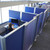 Person working at a desk inside blue fabric office cubicles with frosted panel dividers