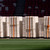 Multiple stacks of white modular flooring panels stored on pallets in a stadium.