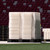 Stack of white modular flooring panels on pallets in a stadium.