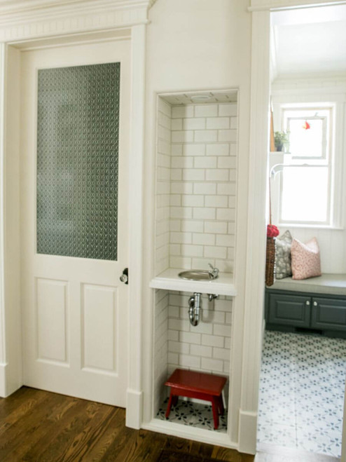 Built-in hallway drinking fountain niche with white handmade subway tile and pearl trim