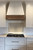 Beautiful White Farmhouse Kitchen with Decorative Tile Backsplash and Wooden Oven Hood Beautiful White Farmhouse Kitchen with Decorative Tile Backsplash and Wooden Oven Hood