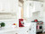 Traditional white kitchen with patterned ceramic tile above range and statement hood