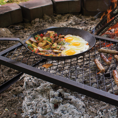 steel skillet on a campfire grate steel skillet on a campfire grate