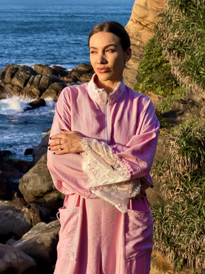 Pink oversized bomber jacket with front zip and delicate lace cuffs on hanger, Eluvare women's luxury casual wear.
