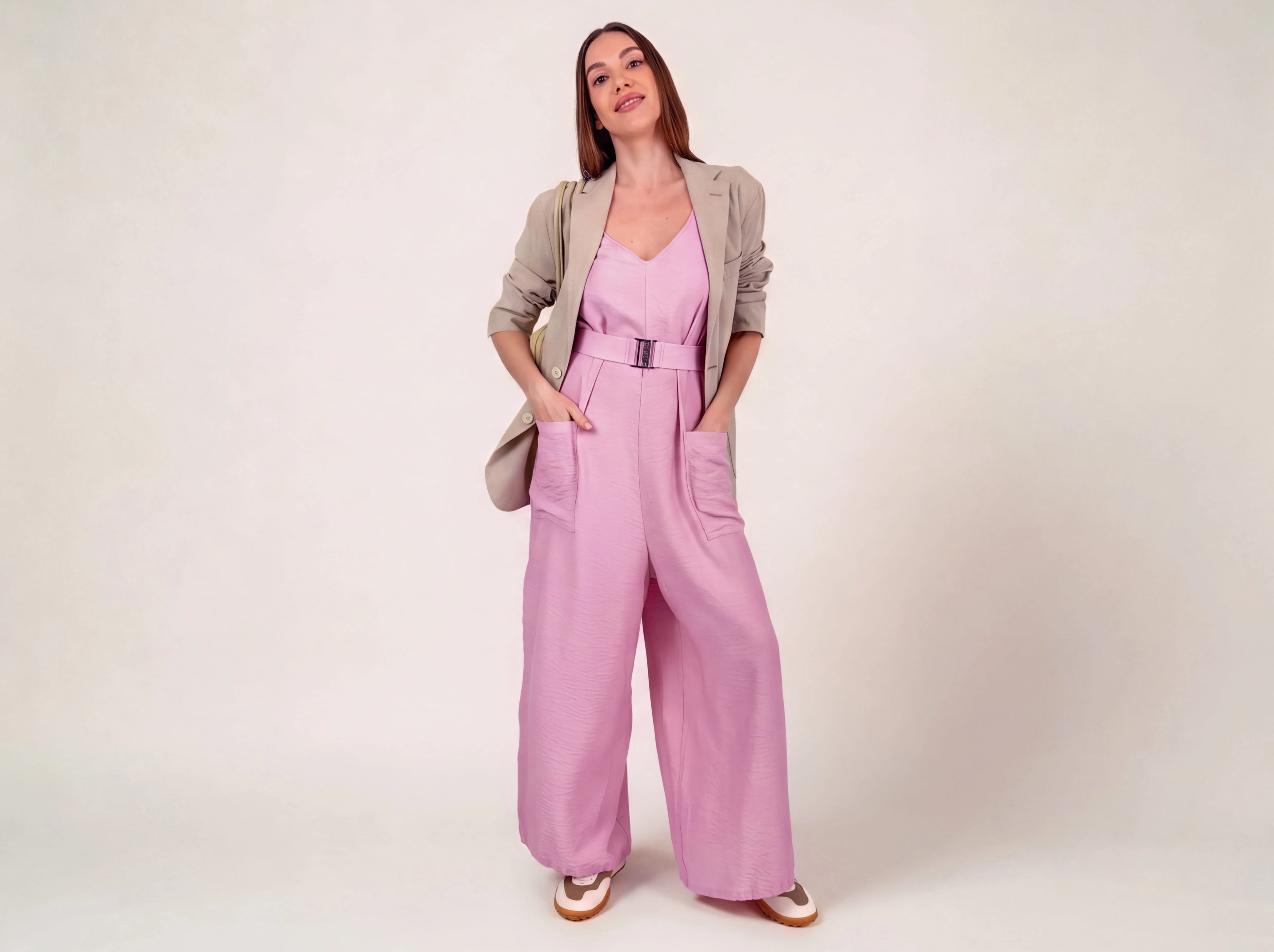 Model wearing the ELUVARE rose jumpsuit in a relaxed outdoor resort setting