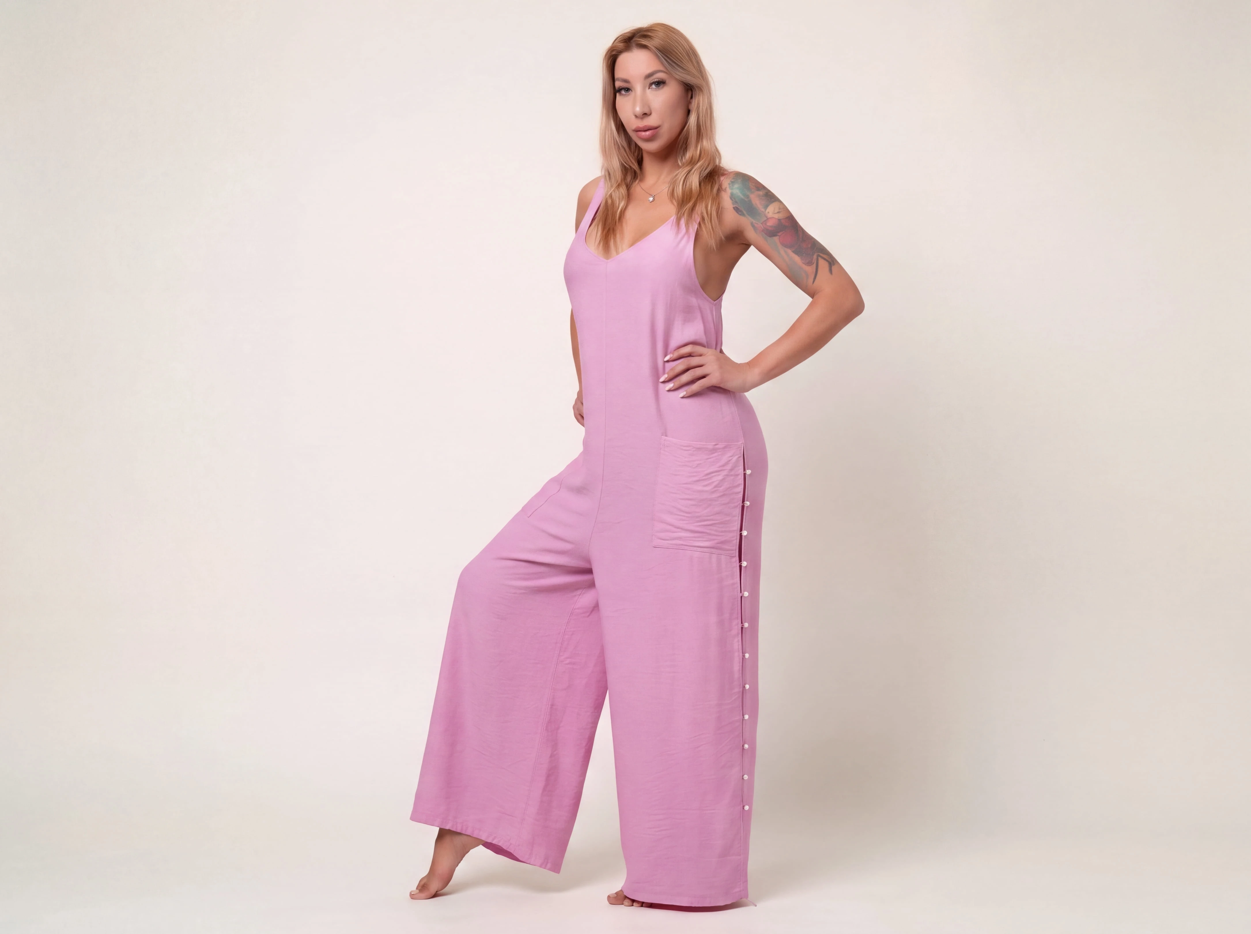 Side profile of the ELUVARE pink jumpsuit with a soft draped silhouette