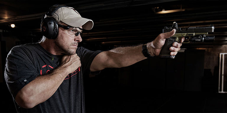 Man at indoor range practicing shooting with his off hand