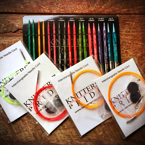 Knitter's Pride Dreamz Interchangeable Circular Knitting Needle Sets, featuring starter, chunky, special, and deluxe options in various sizes, colors, and wooden background from Knitter's Pride brand.