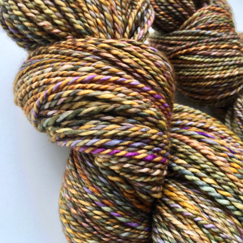 Forever Winding Wool Handmade Merino DK Weight Tweed yarn in small batches from West Virginia, showcasing natural fibers in earthy tones with subtle color variations and purple flecks. Forever Winding Wool Handmade Merino DK Weight Tweed yarn in small batches from West Virginia, showcasing natural fibers in earthy tones with subtle color variations and purple flecks.