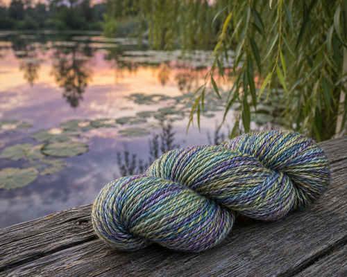 Forever Winding Wool Luxury Handspun Merino Wool Yarn in Reflection, a Monet-inspired colorway, featuring soft multicolored green, blue, and purple hues.