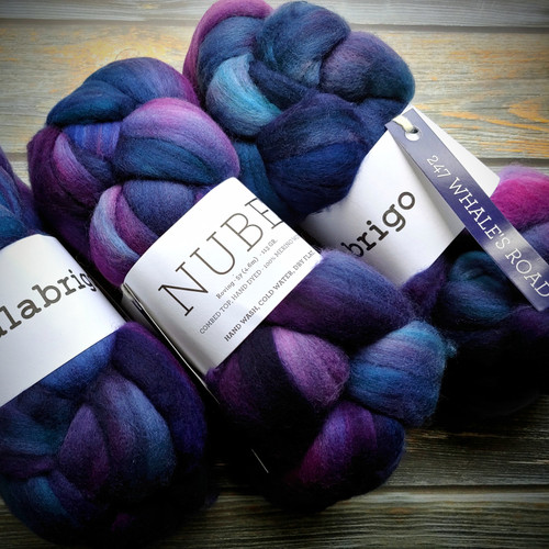 Malabrigo Nube Whales Road 100% Merino Wool Roving, 4oz fiber suitable for spinning and felting, featuring a vibrant blue, purple, and pink color combination.
