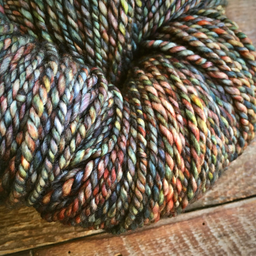 Bulky Artisan Merino Yarn by Forever Winding Wool in Kimball Coal Dust, a multicolored skein featuring earthy tones of brown, green, orange, and blue. Bulky Artisan Merino Yarn by Forever Winding Wool in Kimball Coal Dust, a multicolored skein featuring earthy tones of brown, green, orange, and blue.