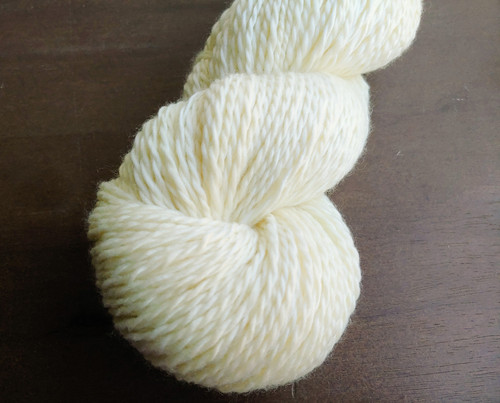 Forever Winding Wool Luxury Undyed DK Weight Merino Wool Yarn, handmade and eco-friendly, a natural cream-colored skein on a wooden surface. Soft, high-quality yarn. Forever Winding Wool Luxury Undyed DK Weight Merino Wool Yarn, handmade and eco-friendly, a natural cream-colored skein on a wooden surface. Soft, high-quality yarn.