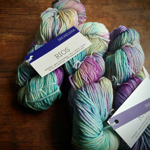 Malabrigo Rios yarn, Melissa color, Superwash Merino Worsted, pastel purple, blue, and green hues, skeins of yarn for knitting or crochet.