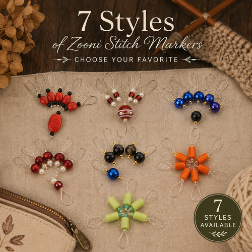Seven colorful Zooni Stitch Markers in various designs, including red, blue, orange, and green, decorative knitting markers and progress keepers displayed on fabric.
